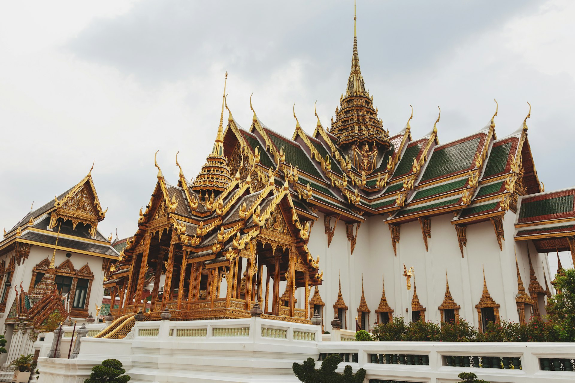 Elaborate golden temple with ornate spires under cloudy sky